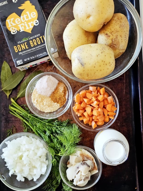 Overhead shot of individual ingredients for rustic Croatian style potato soup in bowls on table